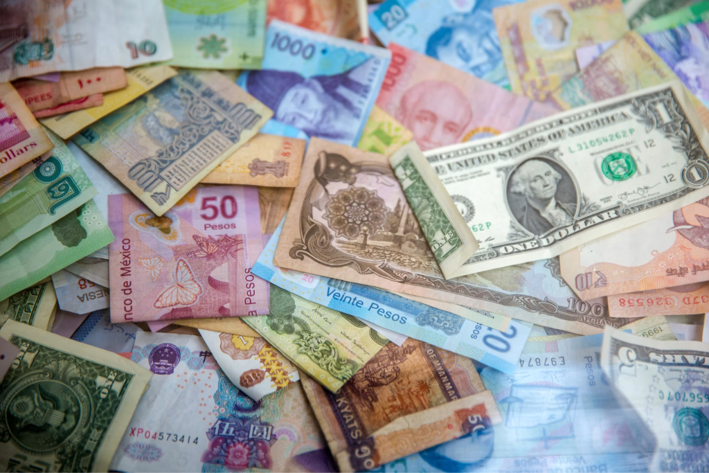 A US dollar note laid over a spread of Asian and Latin American banknotes